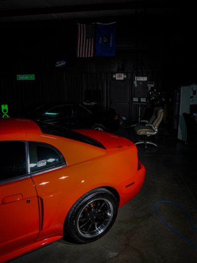Red sports car parked indoors, partially visible.