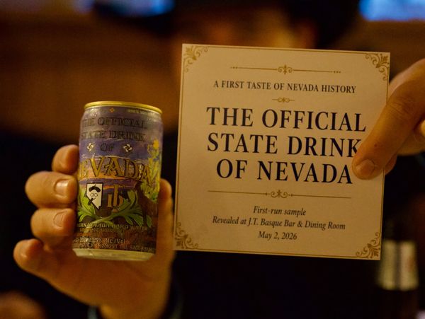 A person holds a can and a card announcing Nevada's official state drink.