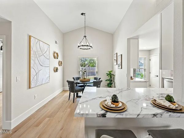 Modern dining area with marble countertop and soft wood flooring.