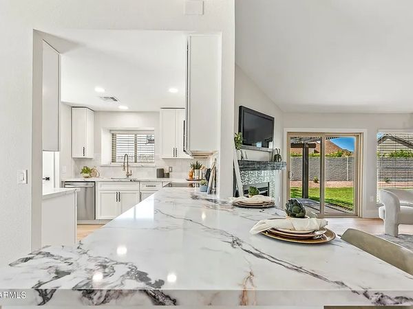 Bright modern kitchen with marble countertop and open living area.