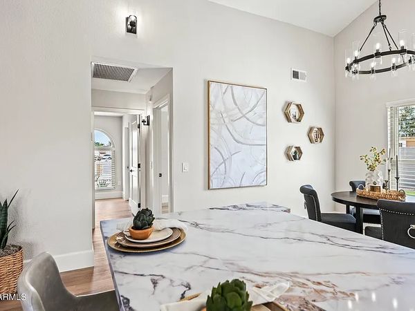 Modern dining area with marble countertop and round table.