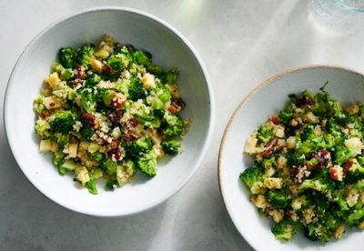 Two bowls of fresh broccoli and quinoa salad with nuts and herbs.