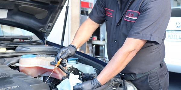 Head mechanic of the auto service and repair shop checking oil from recent oil change job. Encinitas