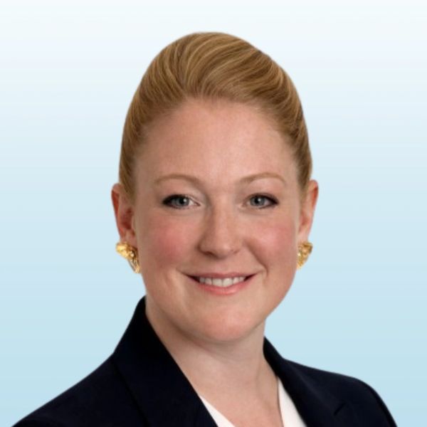 Professional woman with blonde hair in a dark blazer smiling.