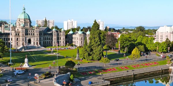 Scenic view of Victoria's waterfront with historic buildings and greenery.