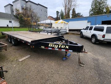 flatbed tandem axle trailer for hauling moving or storing lumber and heavy duty machines. 