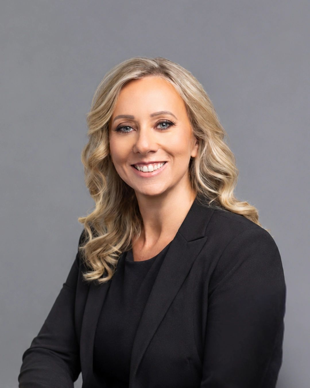 Professional woman smiling in a black blazer.