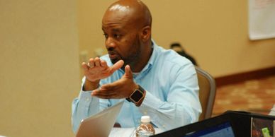 Man speaking to a group at a training session