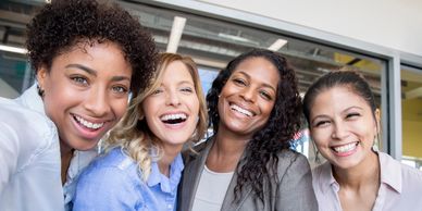 Four young women of color professionals smiling