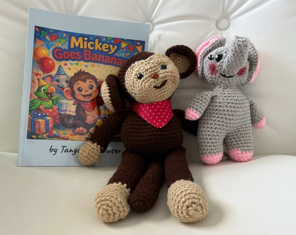 Crocheted monkey and elephant toys with a children's book.