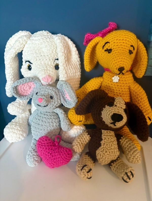 Four crocheted stuffed animals with a pink heart.