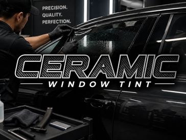 Technician applies ceramic window tint on a car door with precision.