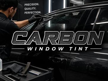 Technician applying carbon window tint on a black car.