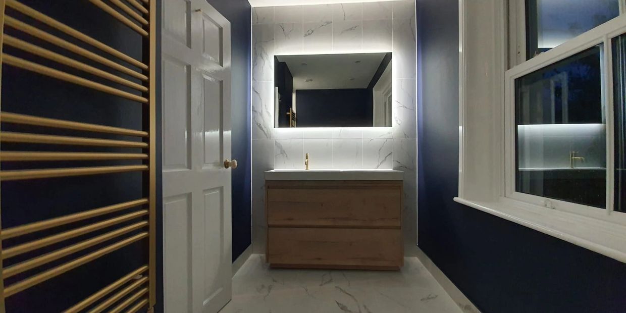 Midhurst bathroom, brass towel rail, navy blue paint, marble tiles
