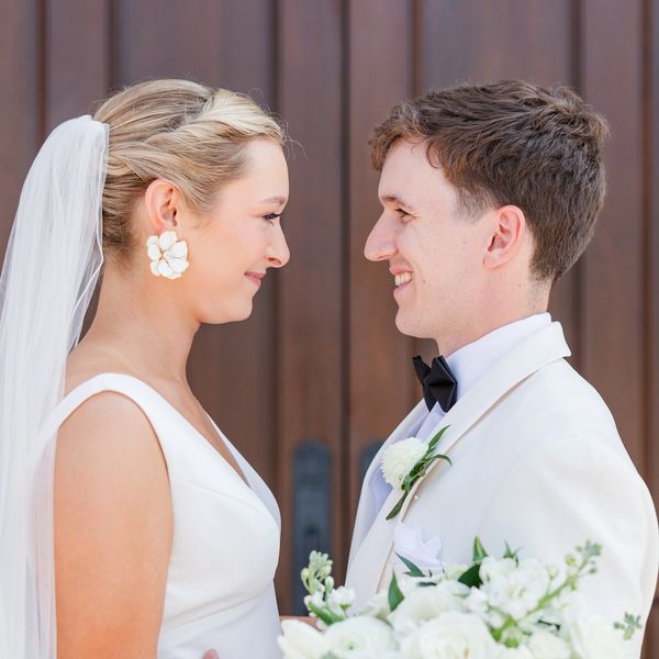 Bride and groom smiling at each other on their wedding day.