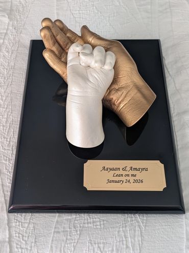 Children's hand casts mounted on black plaque with gold engraved name plate