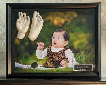 Pearl baby hand and foot casting displayed in a black shadow box with photo and name plate
