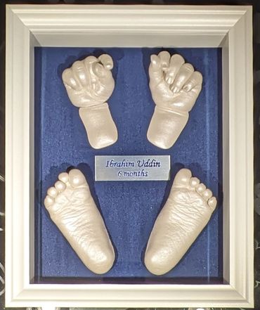 Pearl coloured baby hand & foot casts inside a white 8x10 shadow box with blue and silver name plate