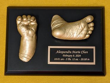 Yellow gold hand and foot casts displayed on a 5x7 black base with gold and black name plate