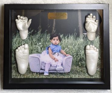 Pearl baby hand and foot casting displayed in a black shadow box with photo and gold name plate
