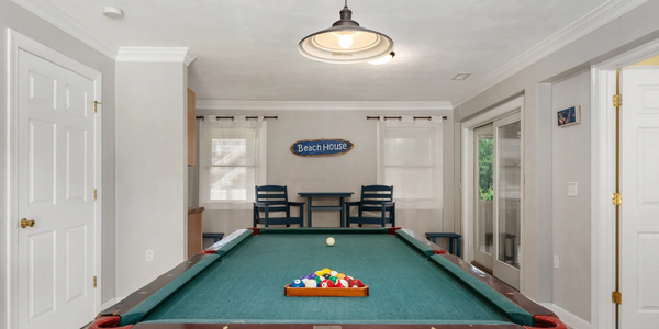 Cozy game room with a pool table and beach-themed decor.