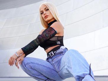 Fashionable woman posing outdoors in trendy clothing.