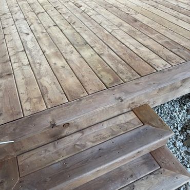 Close-up of angled wooden planks with gravel underneath.
