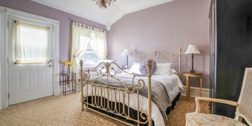 The DeWinters Suite, queen bed, natural lighting and outdoor exit. 