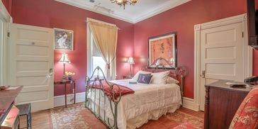 Sherlock Holmes Suite, beautiful red walls, natural lighting, romantic setting.