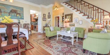 Cozy living room with green sofas and rustic decor.
