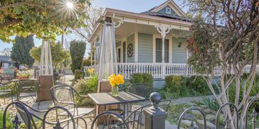 Sunny outdoor seating area with flowers and a Inn.