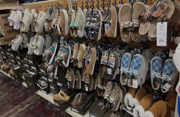 Wall display of various casual shoes and slippers.