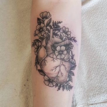 blackwork anatomical heart tattoo with flowers