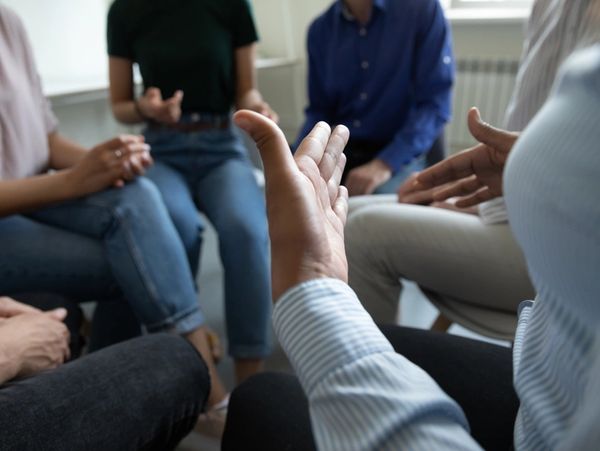 Close up view of diverse people group gathered in circle to discuss work or self problems