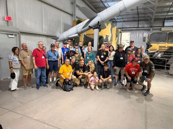 Group photo at military museum with missile display.