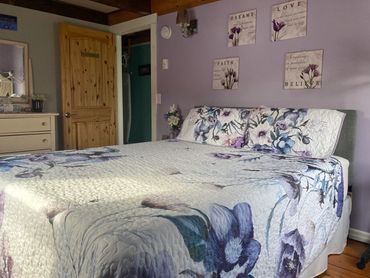 From the southeast corner, you are looking at the Queen bed, antique dresser, and room entrance.