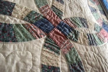 Close-up photo of the "wedding ring" quilt on the Queen bed.