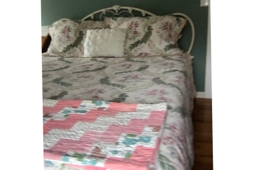 The bedspread on the Queen bed boasts roses and greenery and has matching pillow shams.