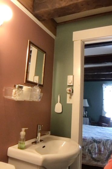 This photo shows the vanity with touch-tone taps looking out to the reading nook in the bedroom.