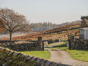 A peaceful rural path winding through stone walls and fields.