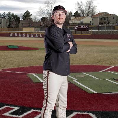 Baseball player posing confidently on the field near home plate.