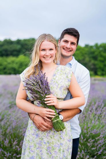 Couple embracing in a scenic lavender field during an outdoor engagement photoshoot