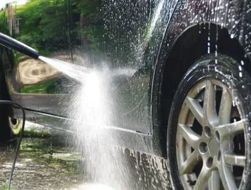 Car being washed with a high-pressure water spray.