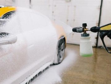 Car being washed with foam spray.