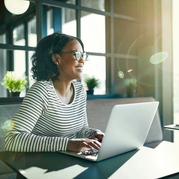 A Woman Smiling at the Laptop Screen