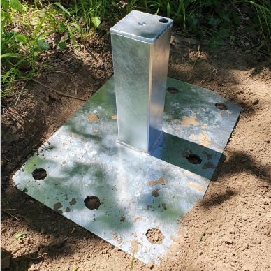 Metal post anchor set in the ground.