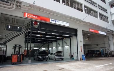 Car workshop with two cars and a forklift.