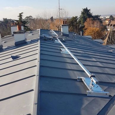 A metal rooftop with safety railing and chimneys.