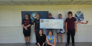 Group of people holding a large check.