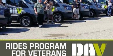 Veterans standing in front of DAV rides program vans.
